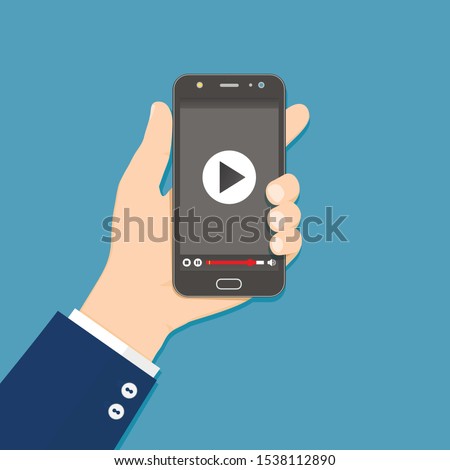 Hand holding smartphone with video player on the screen. Vector flat illustration.
