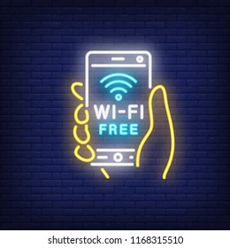 Hand holding smartphone with wi-fi free neon text. Wifi, communication, technology. Advertisement design. Night bright neon sign, colorful billboard, light banner. Vector illustration in neon style.