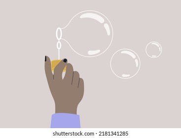 A hand holding a soap bubble blower