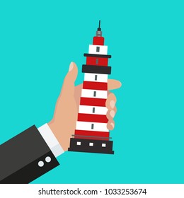 Hand holding a souvenir. Lighthouse souvenir.