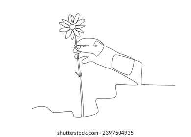 A hand holding a spring flower. Spring one-line drawing