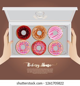 Hand holding sweet donuts in the box
