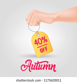 Hand holding tag with autumn, forty percent off lettering. Autumn offer or sale advertising design. Handwritten and typed text, calligraphy. For leaflets, brochures, invitations, posters or banners.