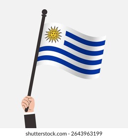 Mão segurando bandeira do Uruguai acenando