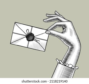 A hand holding a vintage postal envelope. Vintage stylized drawing. Vector illustration