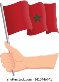 Hand holding and waving the national flag of Morocco. Fans, independence day, patriotic concept. Vector illustration, eps 10.