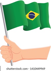 Hand holding and waving the national flag of Brazil. Fans, independence day, patriotic concept. Vector illustration, eps 10.