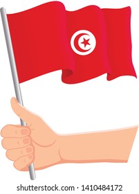 Hand holding and waving the national flag of Tunisia. Fans, independence day, patriotic concept. Vector illustration, eps 10.