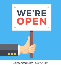 Hand holding we are open banner. Wooden sign, paper placard with title. Store opening, business hours concepts. Modern vector illustration