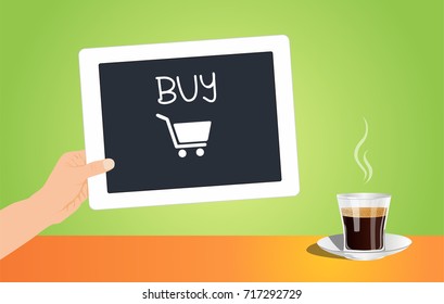 Hand holding white digital tablet with buy button and cup of coffee on a table