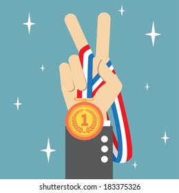Hand holding a winner's medal and showing victory fingers sign 