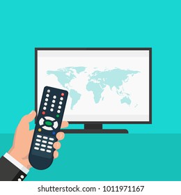 Hand holding wireless remote control near flat screen tv watching world news