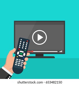 Hand holding wireless remote control near flat screen tv watching video film, cartoon person watching movie on television display
