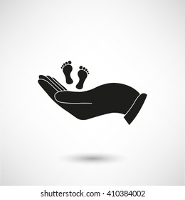 hand holds baby leg - black vector icon  with shadow