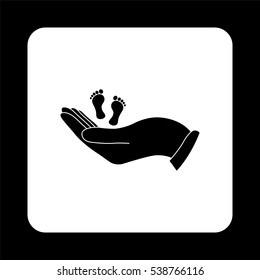 hand holds baby leg  - black vector icon