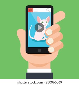 Hand holds black smartphone with open video app and cat on screen. Viral marketing concept.Trendy graphic design elements. Modern creative vector flat illustration. Isolated on trendy green background