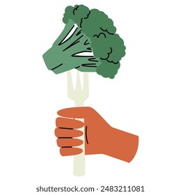 Hand holds broccoli on a fork.