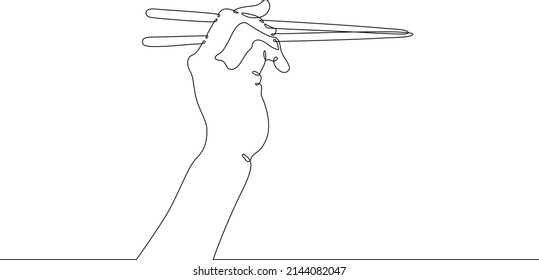 The hand holds chopsticks. Asian traditional cutlery.One continuous line drawing. Line Art isolated white background.