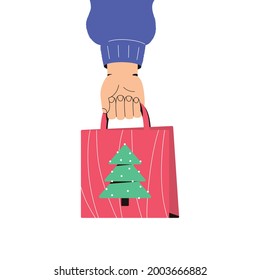 Hand holds a Christmas gift package. The concept of preparing for the winter holidays. Christmas shopping. Advertising web banner for Christmas