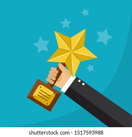 hand holds a golden star award on a stand