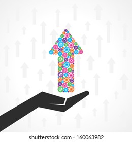Hand holds group of gears coming together to form the shape of an upward arrow for the business concept of financial success