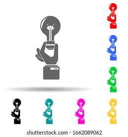 Una mano sostiene un icono de luz ideas de varios colores. Glifo simple, vector plano de succión e iconos de premios para ui y ux, sitio web o aplicación móvil