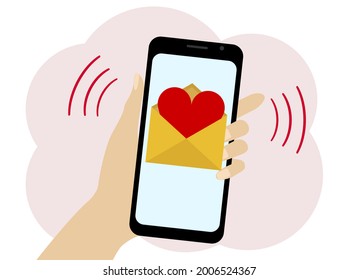 Hand holds a mobile phone with a picture of a letter with a red heart