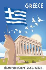 Hand holds the national flag of Greece on the background of the Parthenon building in Athens.