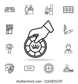 The hand holds a playing chip icon. Detailed outline set of casino element icons. Premium graphic design. One of the collection icons for websites, web design