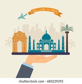 The hand holds the sights of India on a tray. The plane and the words welcome to India on the ribbon