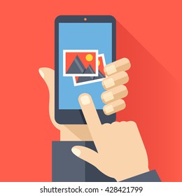 Hand holds smartphone with photos icon on smartphone screen. Multimedia, photo album app concept. Modern simple flat design for web banners, web site, infographics. Creative vector illustration