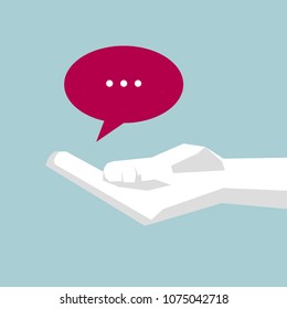 A hand holds speech bubble icon. Hand is white,Background is blue.