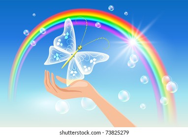 The hand holds a transparent butterfly against a rainbow. Symbol of environmental protection