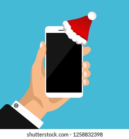 Hand holds white smartphone with Santa hat. Phone like a gift, present for New Year and Christmas. Ready banner template for your advertisement. Technology store poster concept. Vector illustration.