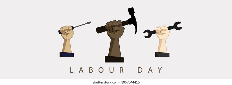 Hand holds a wrench, hammer, screwdriver. Labor Day. 