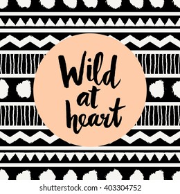 Hand lettered inspirational quote "Wild at Heart", pastel orange colored circle, tribal geometric pattern background. Modern greeting card, poster, t-shirt design.