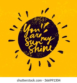 Hand lettered inspirational quote 'You are my sunshine'. Expressive brush hand lettering on grungy yellow background.