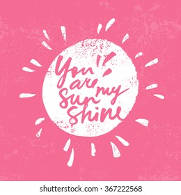 Hand lettered inspirational quote 'You are my sunshine'. Expressive brush hand lettering on pink background.