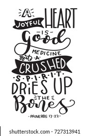 Hand Lettering A Joyful Heart Is A Good Medicine But A Crushed Spirit Dries Up The Bones on White Background. BIble Lettering. Hand Lettered Quote. Modern Calligraphy. Inspirational Motivational Quote