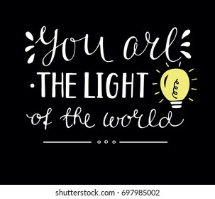 Hand lettering You the light of the world, made with glowing light bulb. Biblical background. Christian poster.Modern calligraphy. Card.