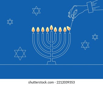 Hand Lighting Candle On Metal Hanukkah Menorah On Surface Against Blue Background. Man lighting up candles in menorah. Jewish Woman Celebrating Holidays Hanukkah