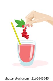 A hand lowers a branch of red currant with a fresh leaf into a glass with a drink and a straw