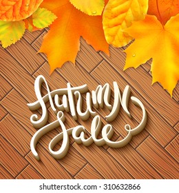 Hand made lettering Autumn sale over wooden background with leaves