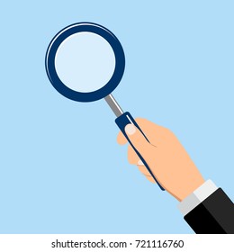 hand with a magnifier on a blue background