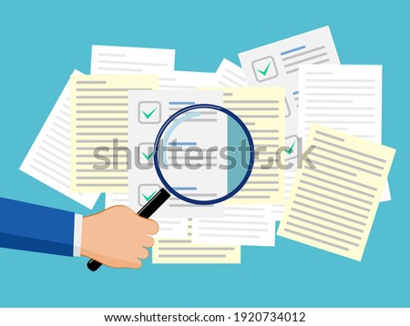 Hand with a magnifying glass to search for important documents