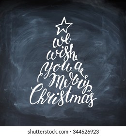 Hand painted brush lettering We wish you a Merry Christmas. Calligraphy inscription inside the fir tree. Vector hand drawn typography. Chalkboard.