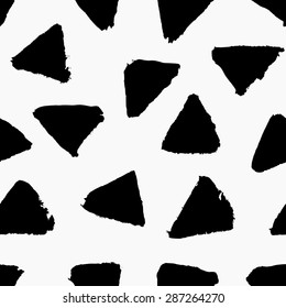 Hand painted triangle shapes in black on white background. Seamless abstract repeating hand drawn background.