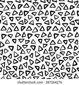 Hand painted triangle shapes in black on white background. Seamless abstract repeating hand drawn background.