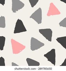 Hand painted triangle shapes in pink, light and dark gray. Seamless abstract repeating hand drawn background.