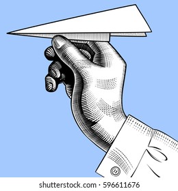 Hand with a paper plane. Vintage engraving stylized drawing. Vector Illustration